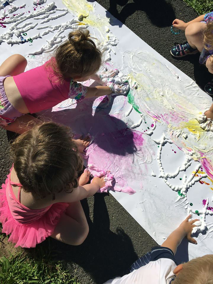 Kids making shaving cream art.